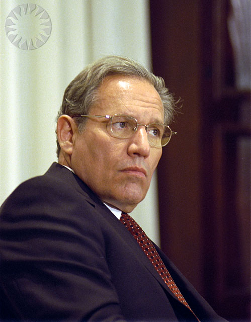 a man sitting down in a business suit looking off into the distance