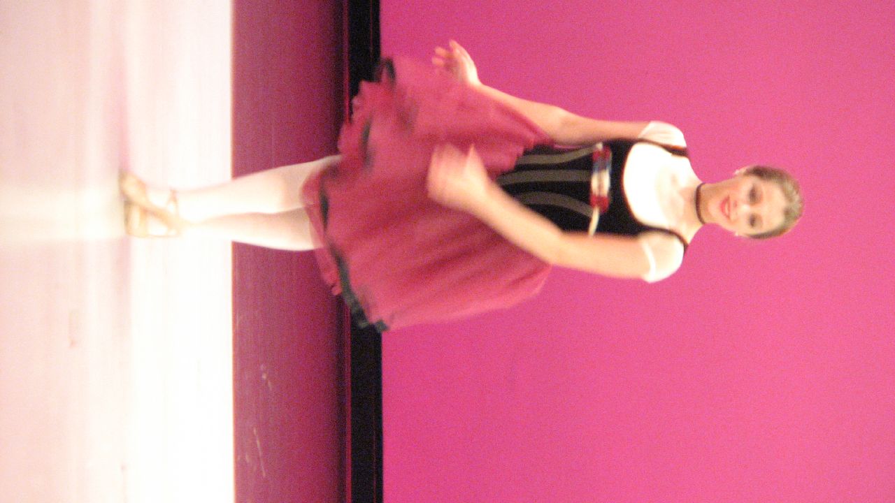 a ballerina in pink poses while dancing