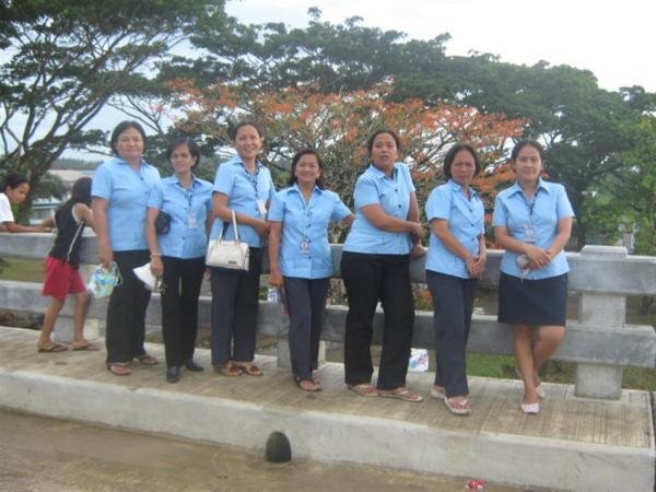 eight people posing for the camera with blue shirts