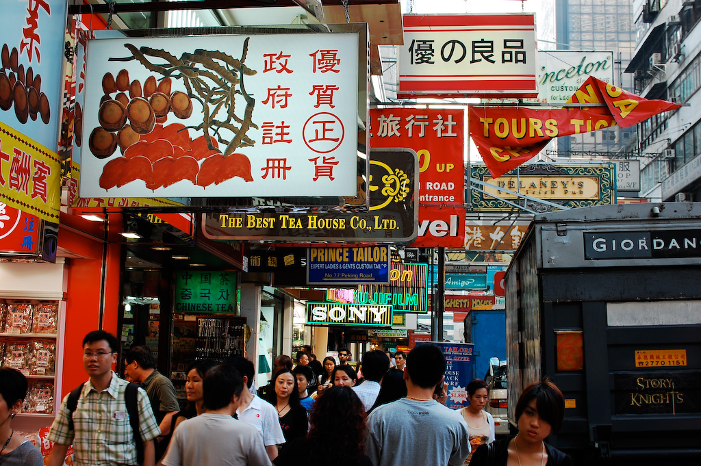 a group of people standing around in front of stores