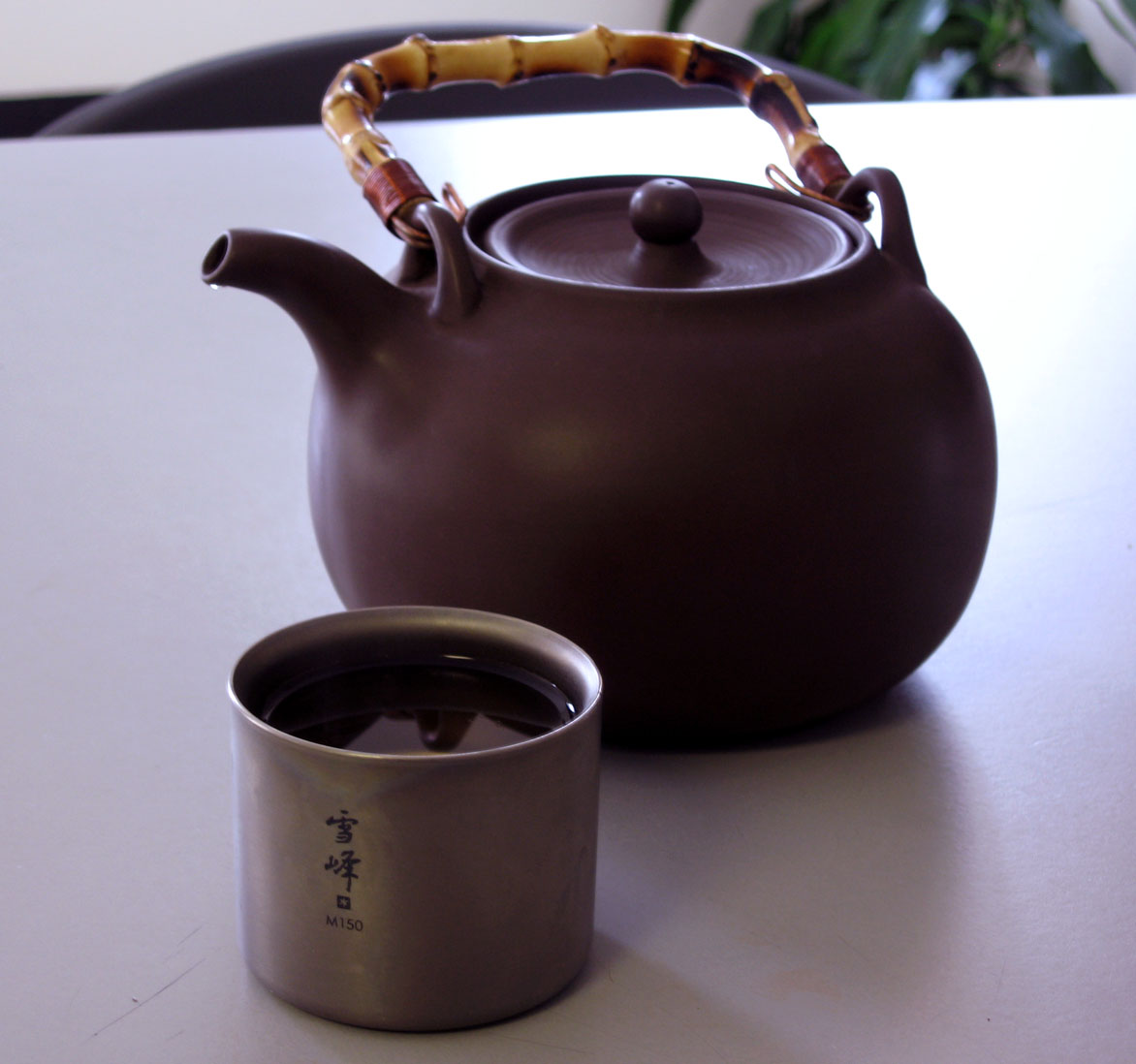 a tea pot and cup sitting on top of a table
