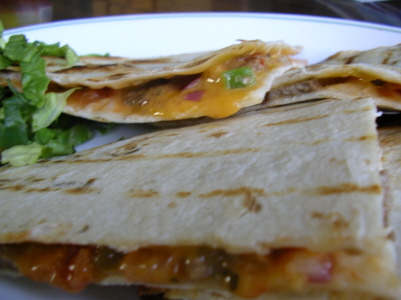 a plate with three quesadillas and lettuce on it