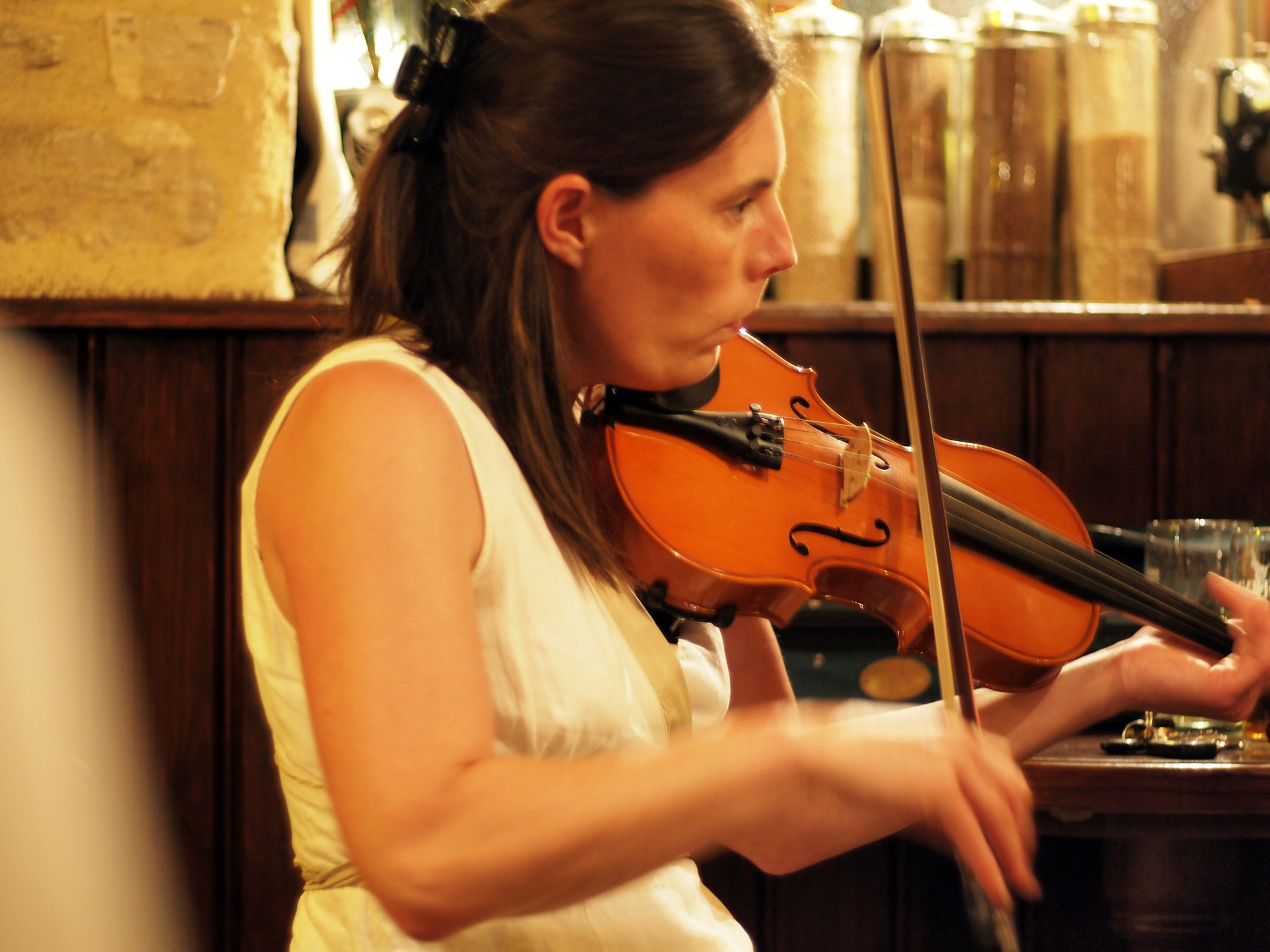 a woman is playing a violin in front of a table