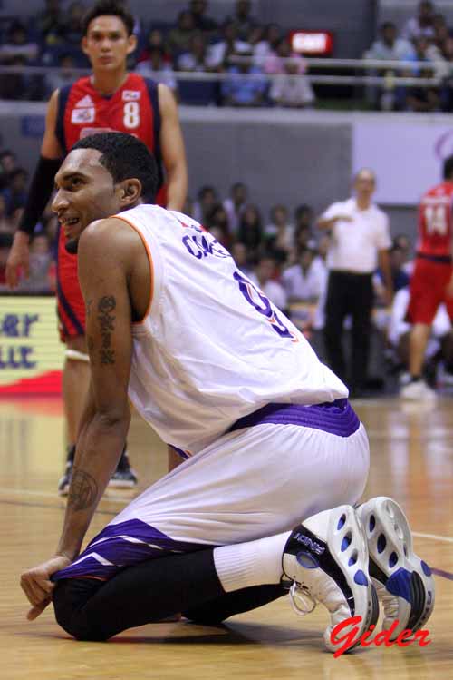 a man kneeling on the floor in front of a basketball