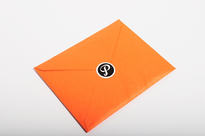 an orange envelope that has a small on on it