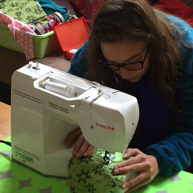 a woman is working on an electronic sewing machine