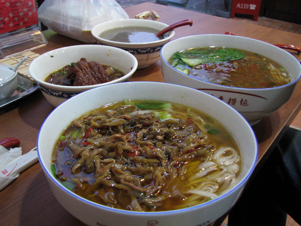 bowls of various soup are on the table, including noodles and vegetables