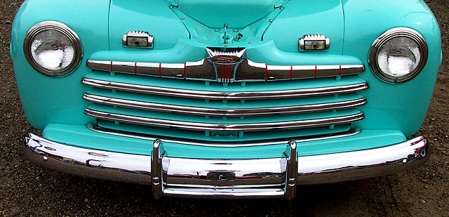 an old pick up truck parked next to a tree