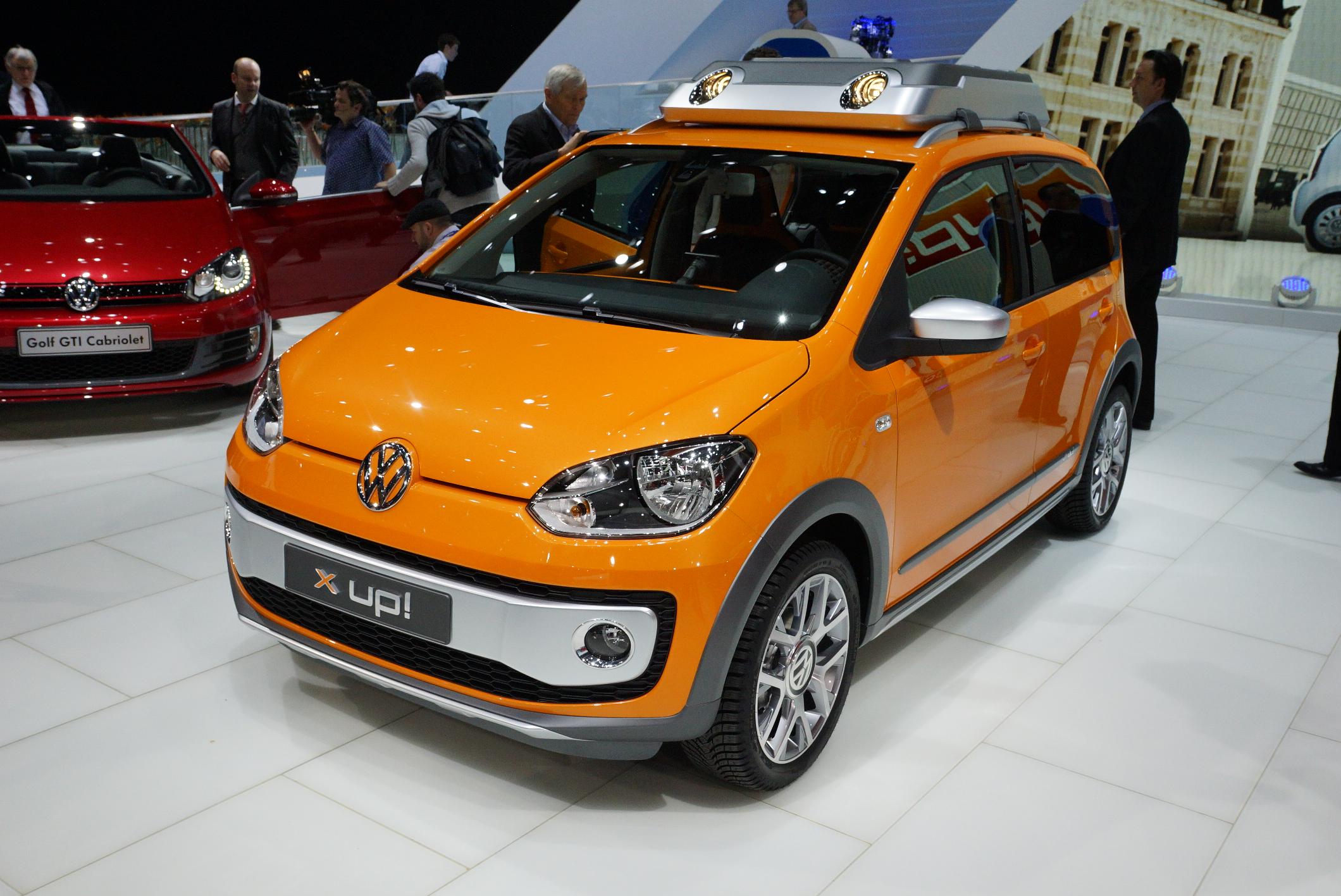 a small yellow car is on display at a show