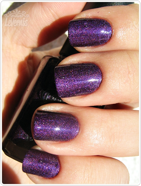 woman in hand holding onto a purple nail polish