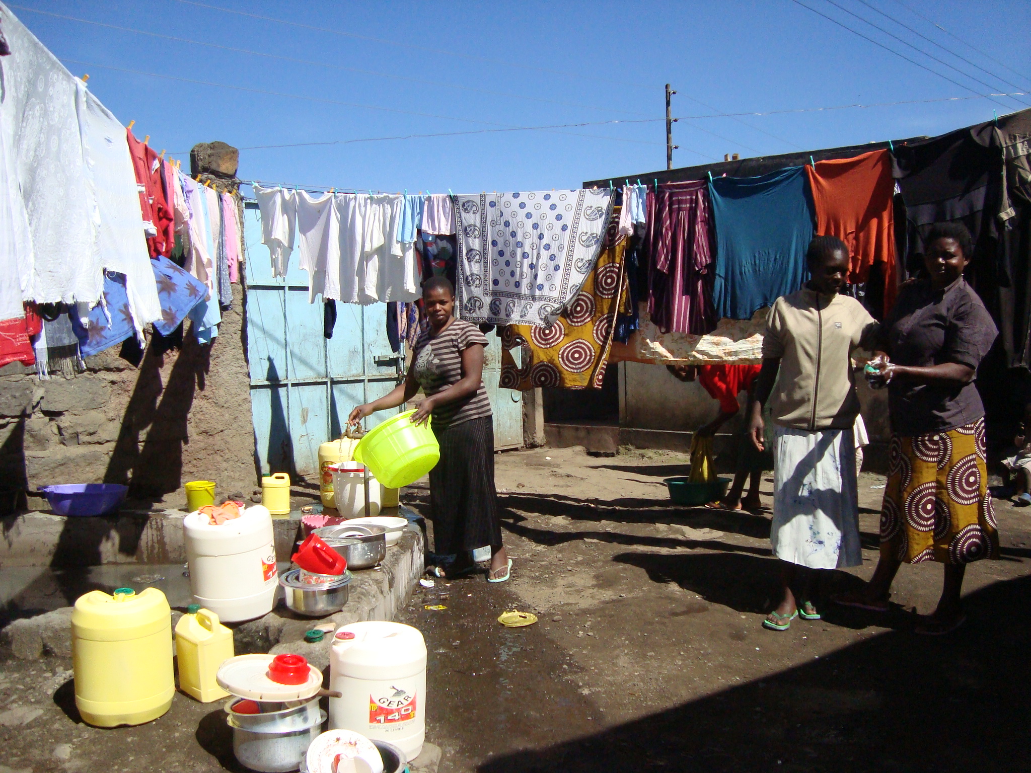 women in an african village hanging laundry from their line