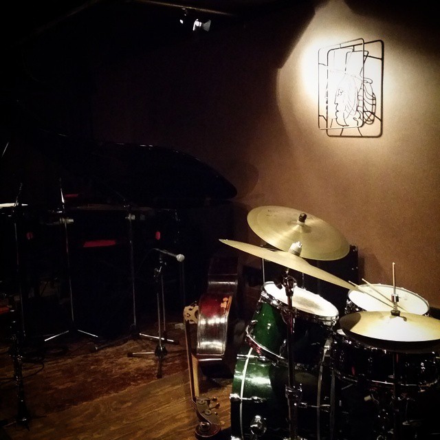 a drum and sticks set up against a brown wall