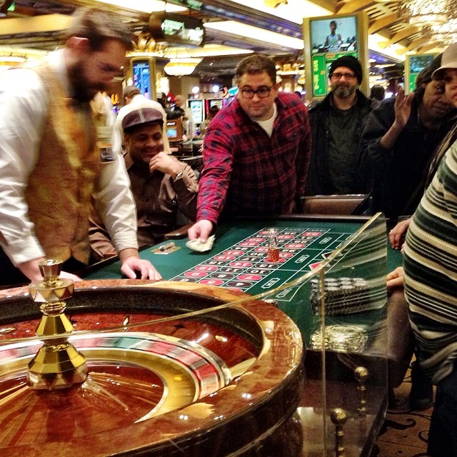 people playing roulet while watching and watching the slot game