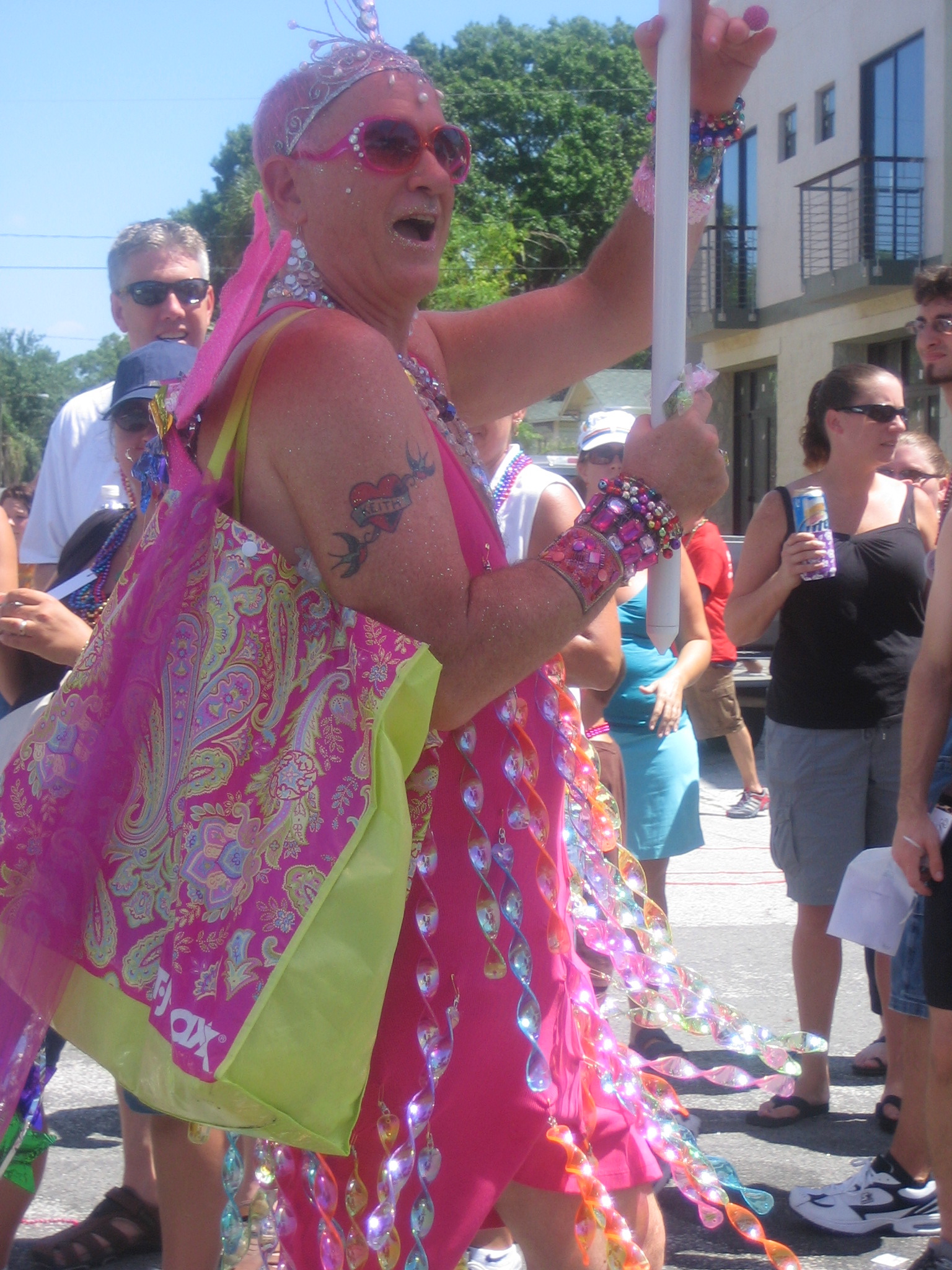 woman in pink dress holding sign with many decorations