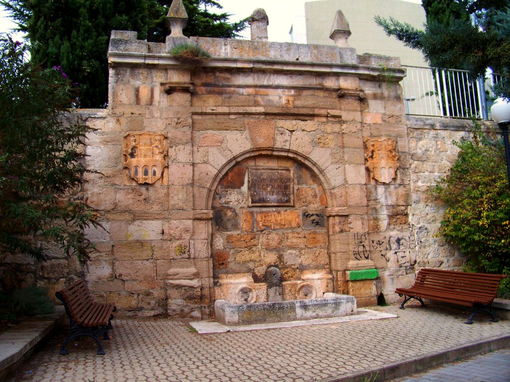 a large stone fountain with benches around it