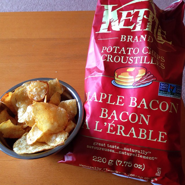 a bag of potato chips sitting next to a bowl of bacon
