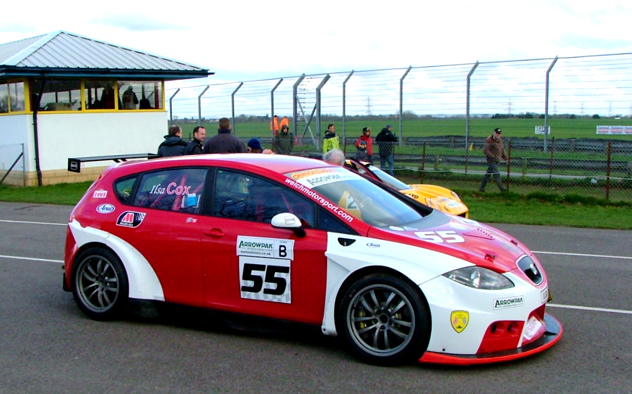 a man and woman in racing cars driving on road