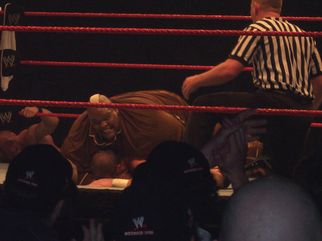 two men sitting next to one another in a wrestling ring
