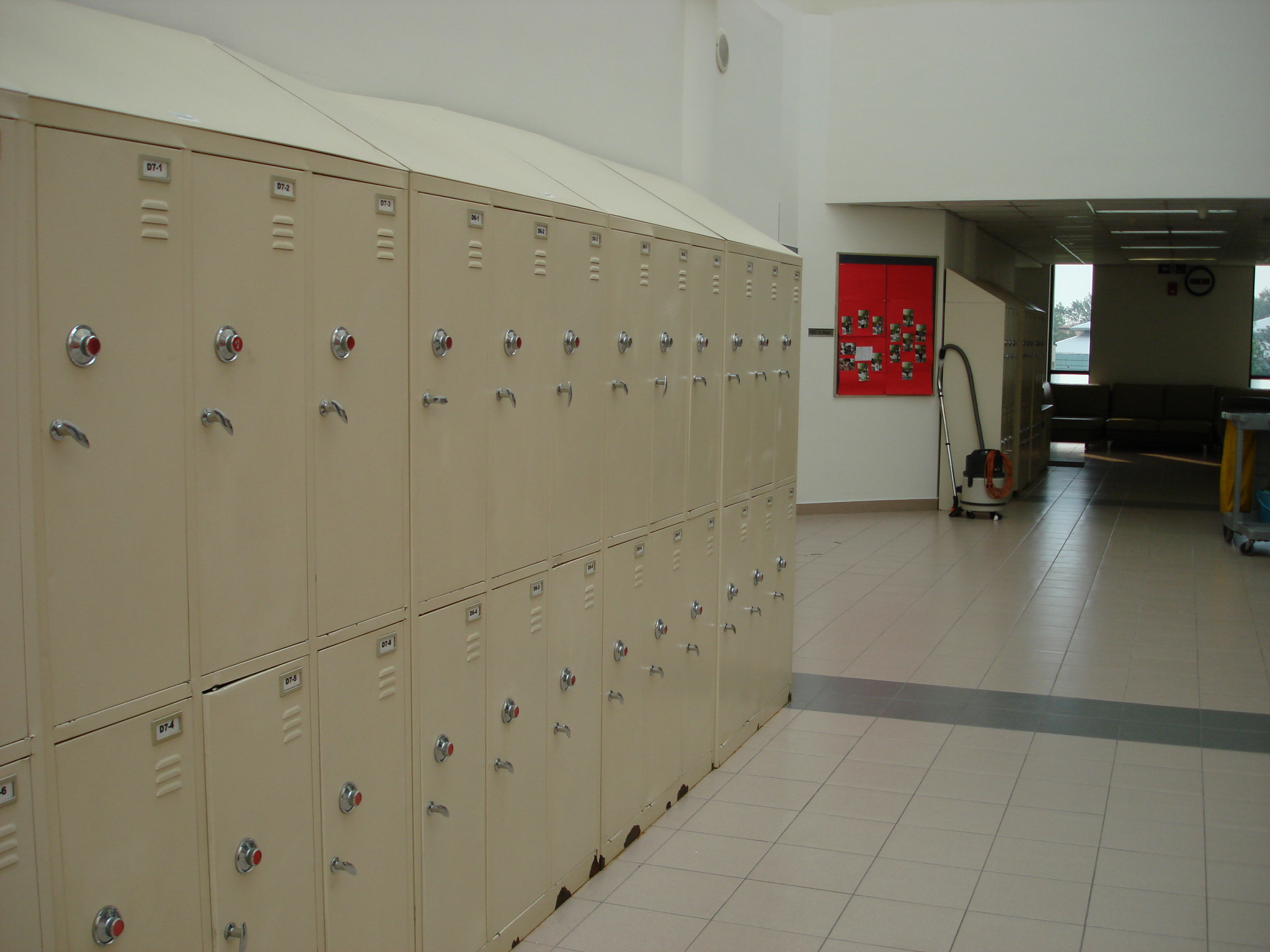 many beige lockers with keys and locks on them in a hallway
