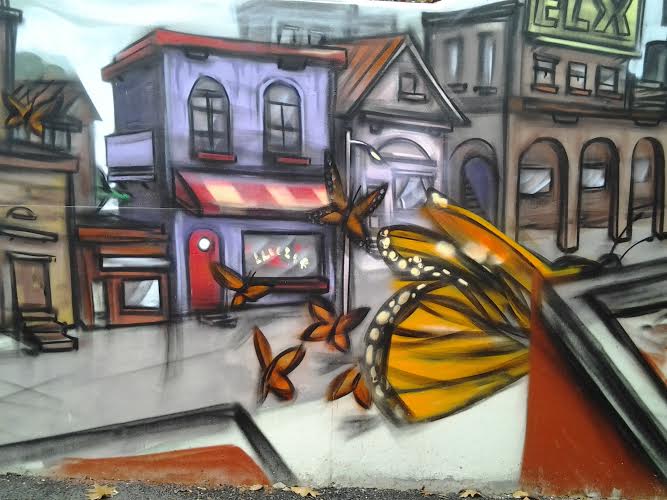 a street painting of a yellow erfly on the side of a building