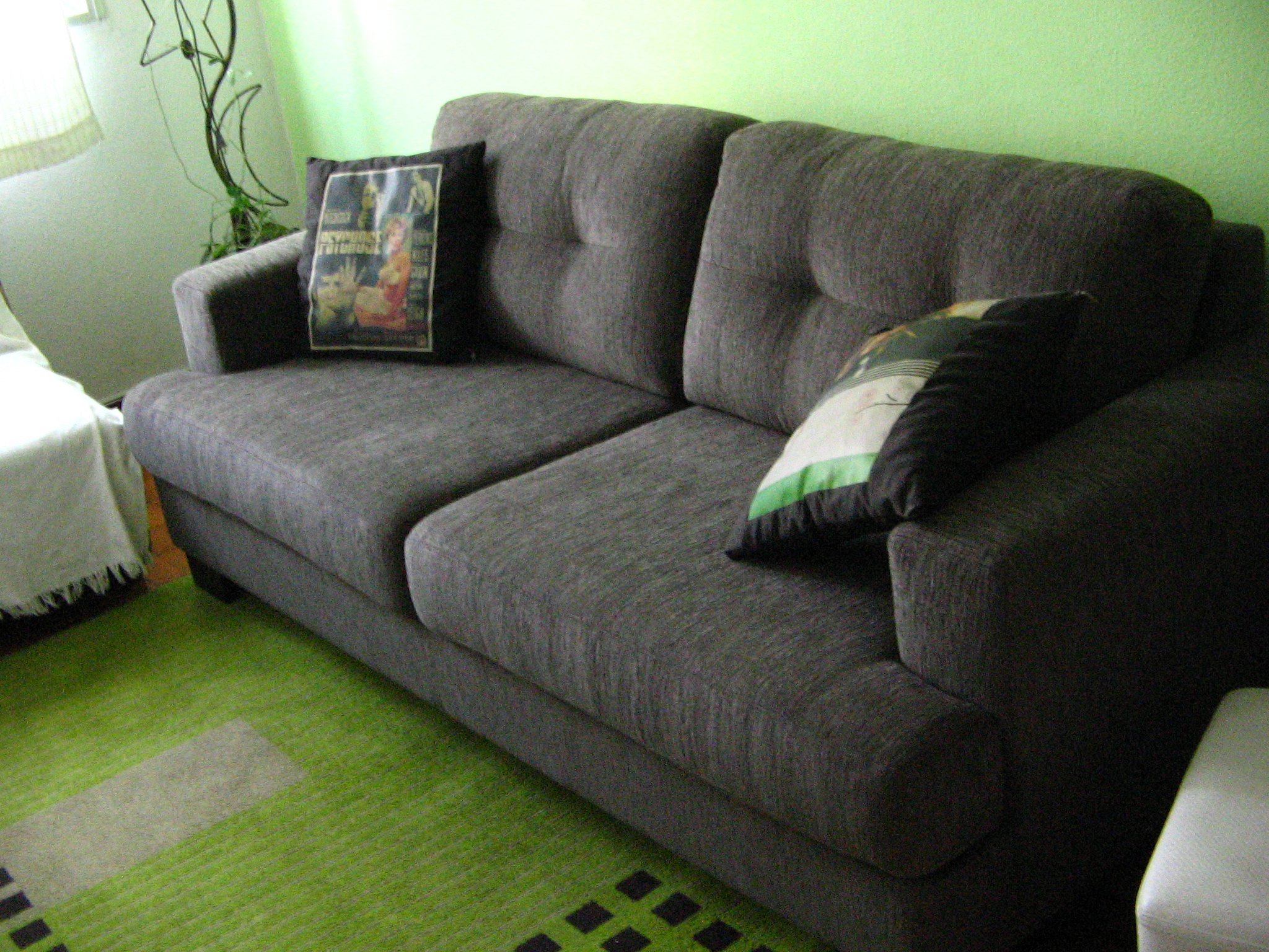 a black sofa with pillows on the back