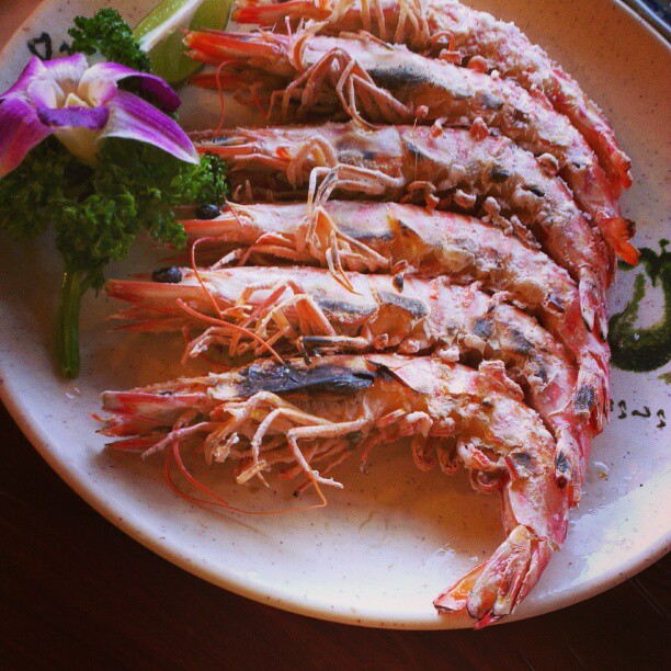 plate of steamed lobsters with a purple flower on a wooden table
