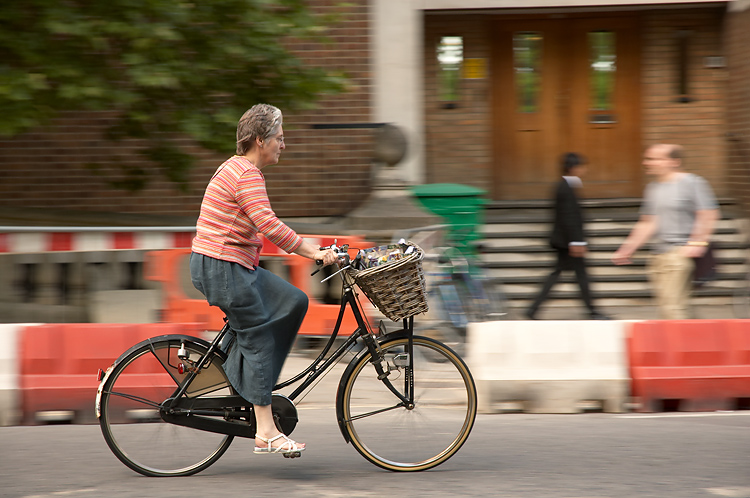 a lady is riding on the bicycle in a street