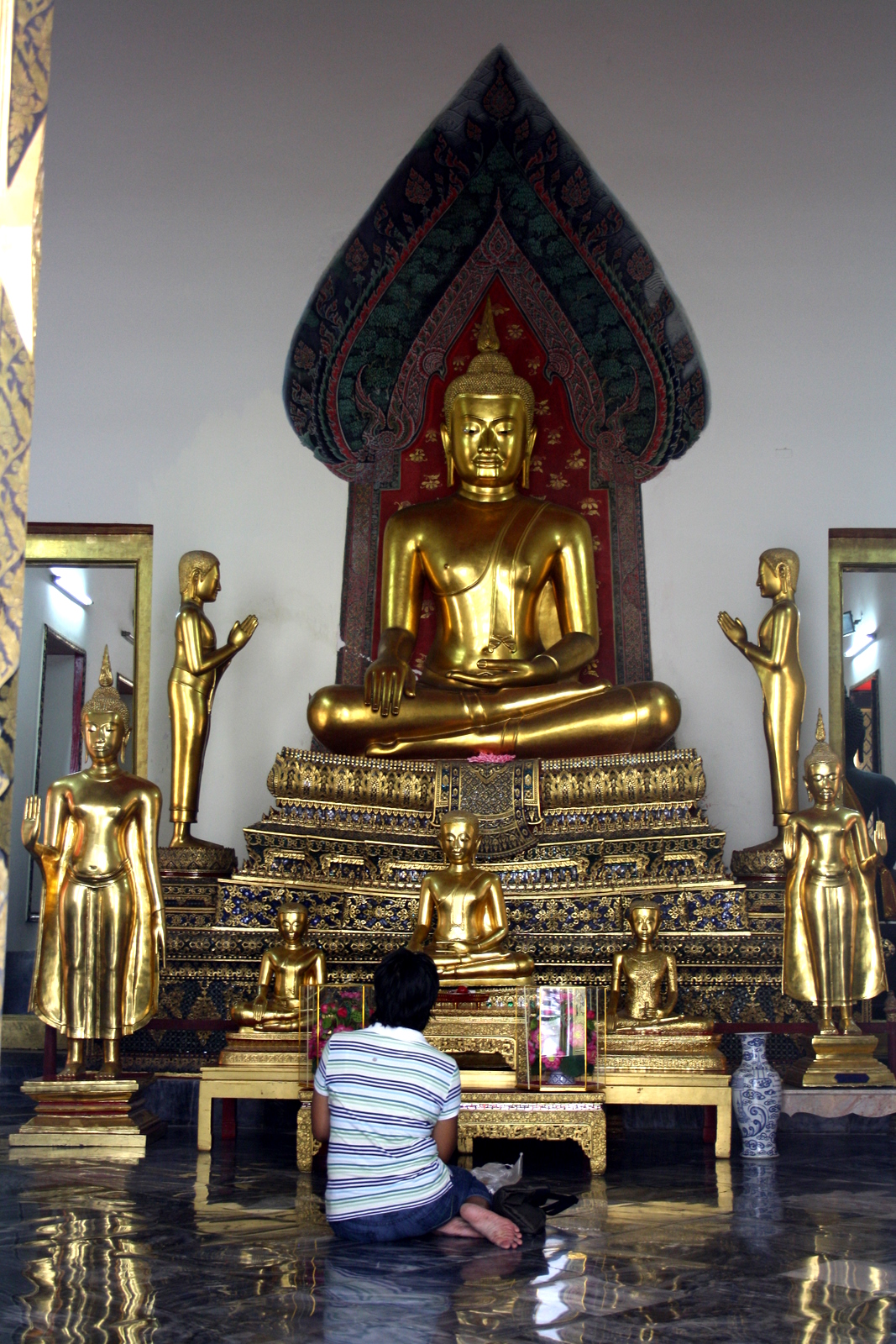 the golden buddha is sitting in front of its own statue