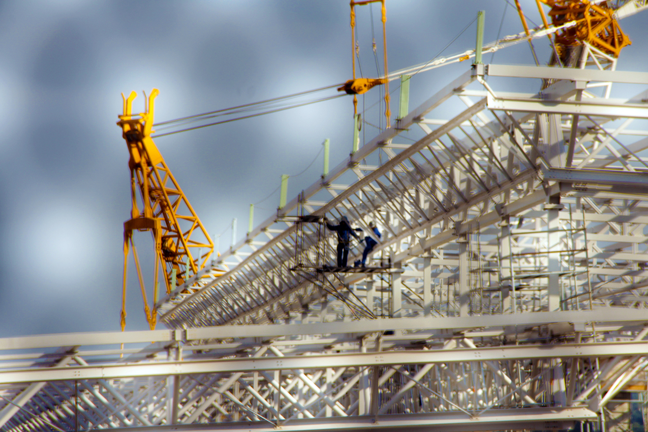 two construction workers on the side of a metal structure