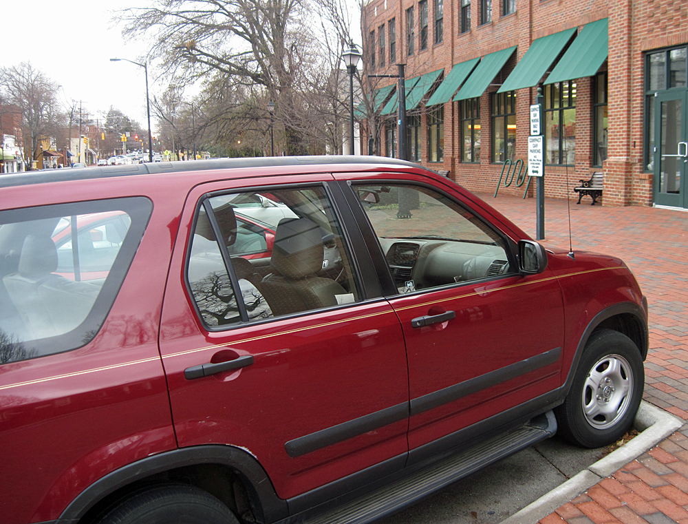 the back of a car is shown parked on the sidewalk