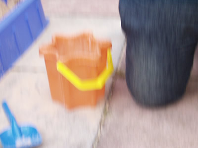 a person with their legs crossed walking next to plastic containers
