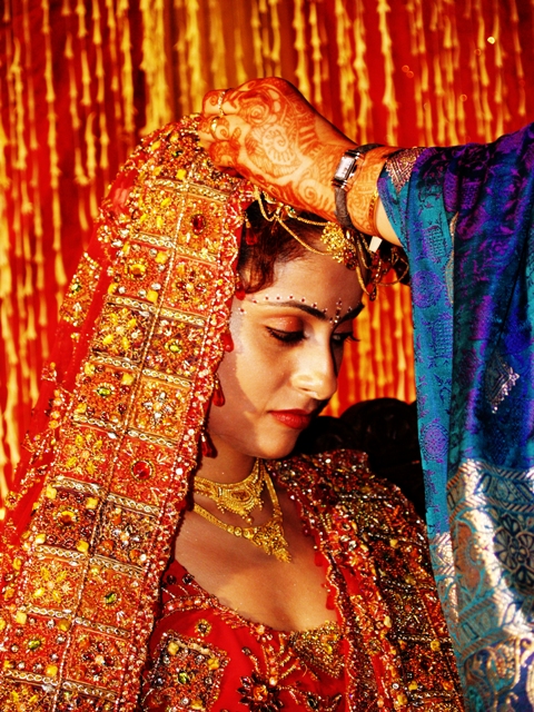 a person wearing a sari with gold jewelry on their head