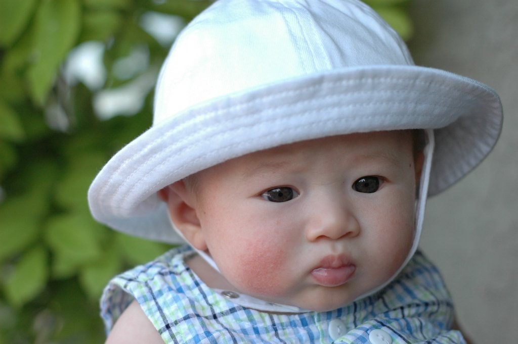 a baby wearing a white hat with a on in the center