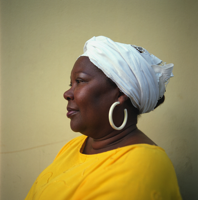 a woman wearing a yellow shirt has her head wrapped up