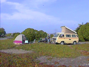 yellow van and tent set up in a grassy area