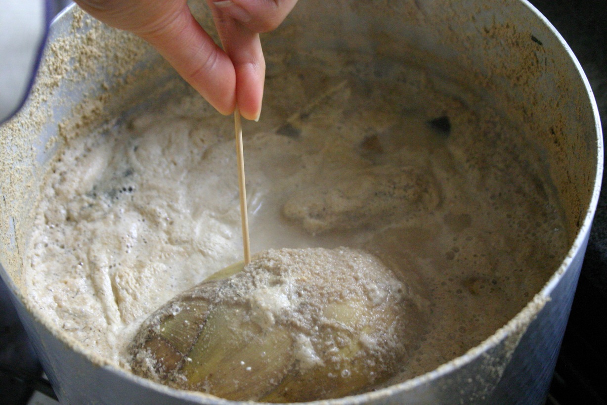 someone dropping ingredients into a pot of flour