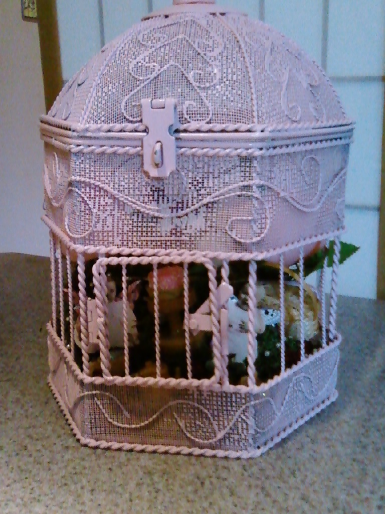 white bird cage with flowers inside of it