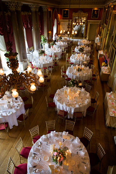 an indoor banquet hall filled with white tablecloths and chairs