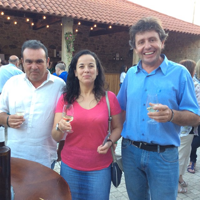 three people in colorful shirts and jeans pose for a po