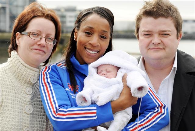 two adults and a baby posing for a picture