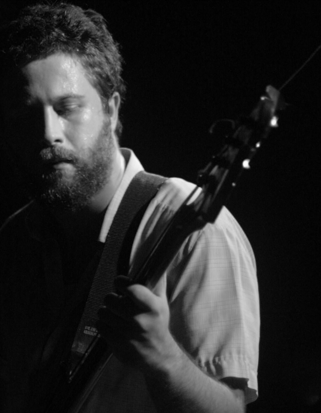 a man playing guitar and a microphone on stage