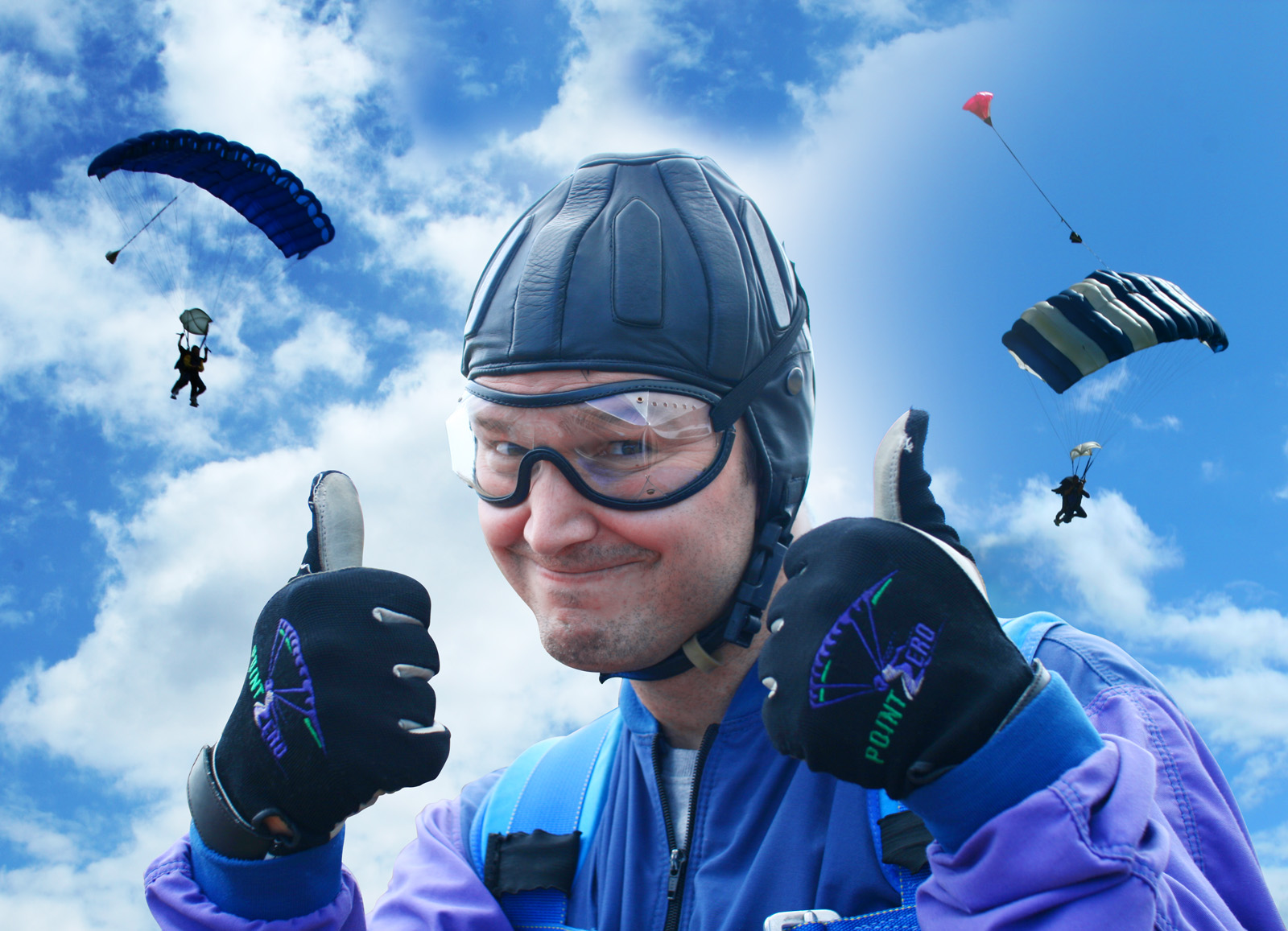 an airborne man wearing protective gear holding his thumb up