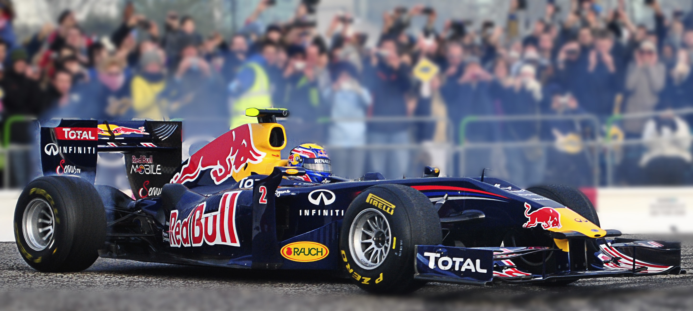 a red bull car going past the stands