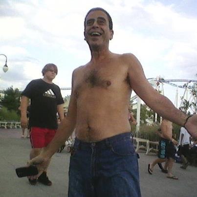 a shirtless man holding soing over his hip