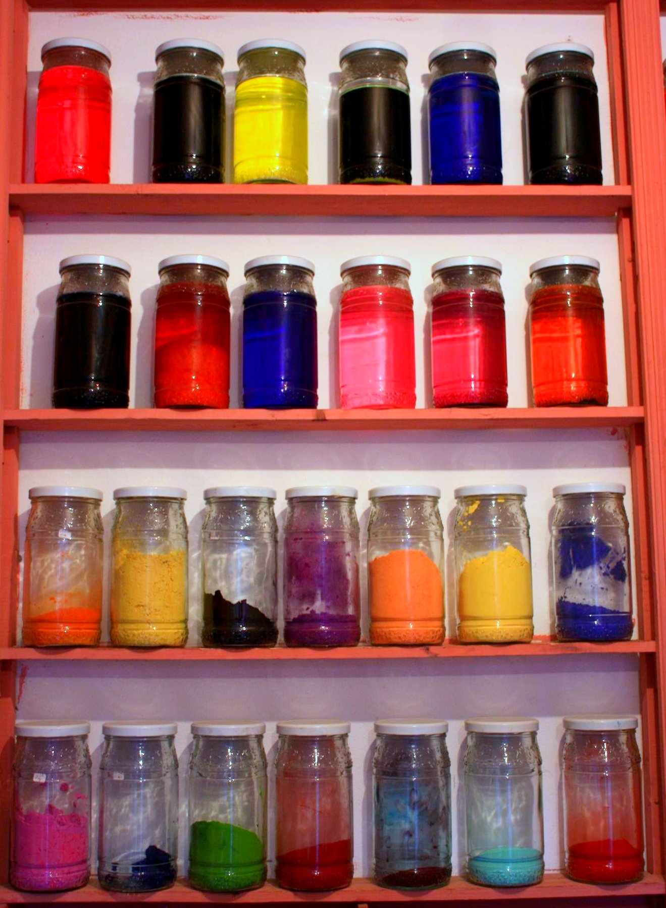 a shelf filled with jars and other types of paint