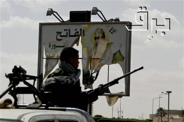 man walking next to a billboard with guns in hand