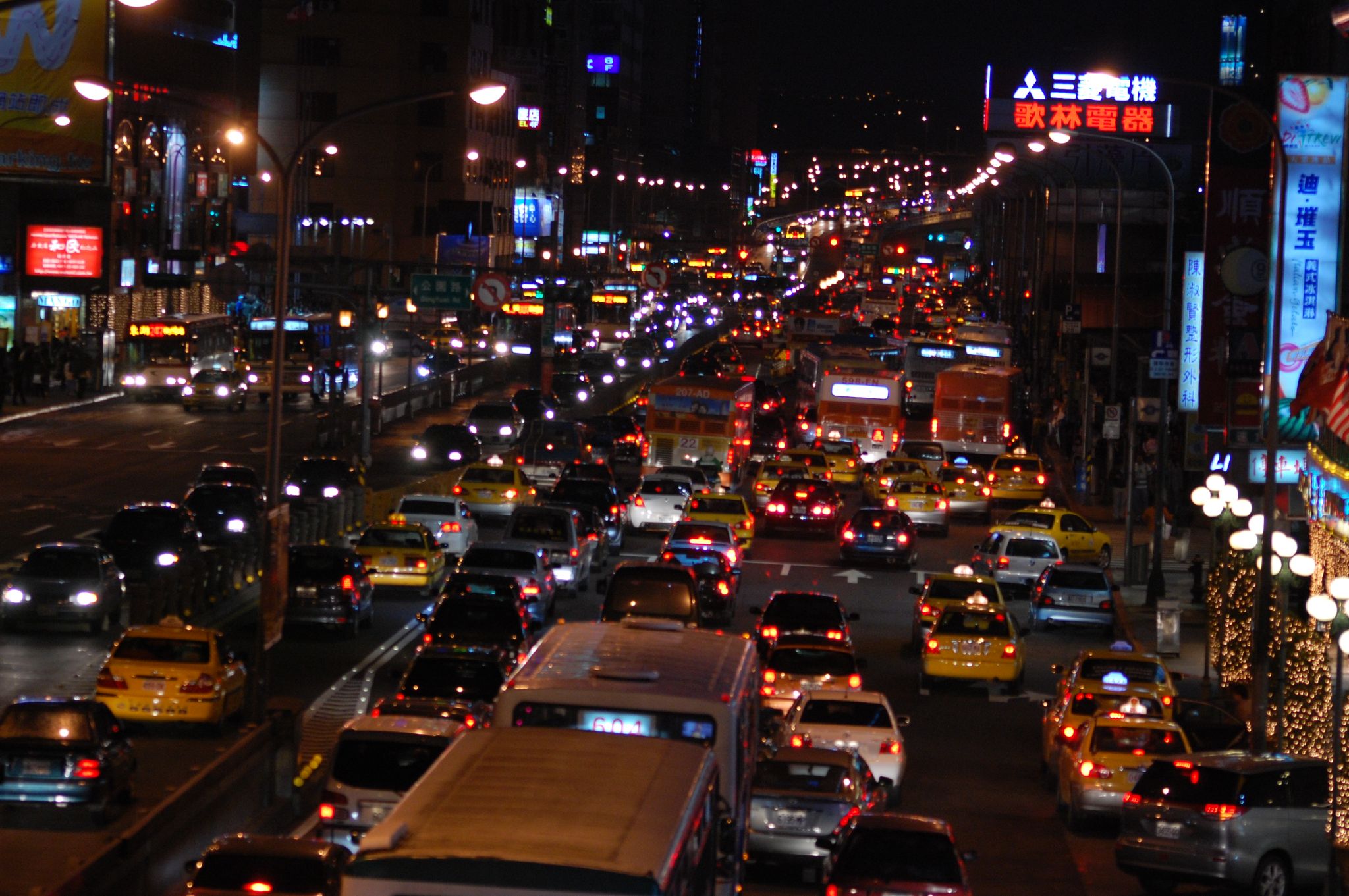 a street filled with lots of traffic and lit up lights