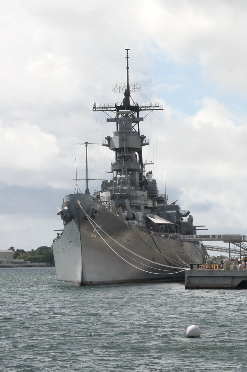 two ships docked in a harbor with blue skies and clouds