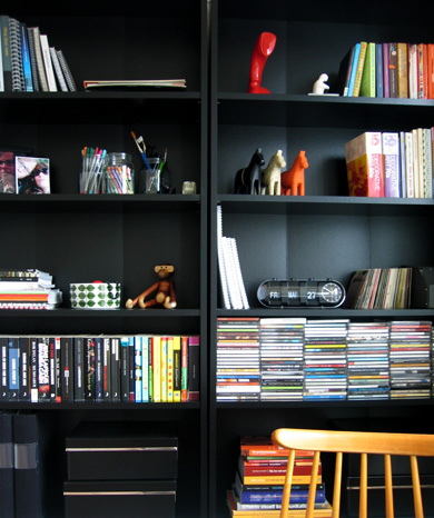 a living room with two black book cases filled with books