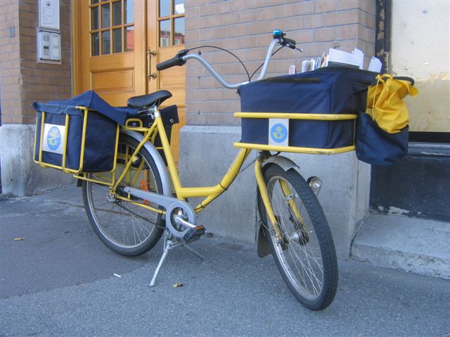 a yellow bike parked by a brick building